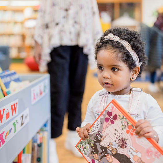 Barn håller bok på bibliotekets barnavdelning